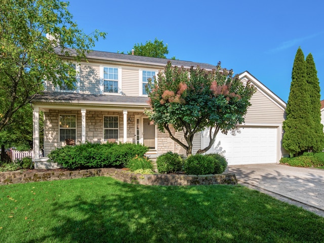 304 Cottage Grove Cir, Pataskala, OH 43062 - traditional-style house with concrete driveway, a garage, a front lawn, stone siding, and covered porch