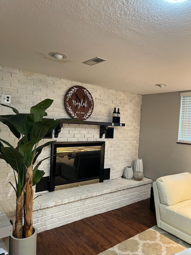 1853 Shasta Dr, Lancaster, OH 43130 - living area featuring a brick fireplace, a textured ceiling, and wood finished floors