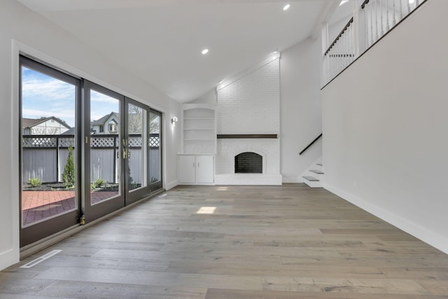 5200 Colt Ct, Westerville, OH 43081 - unfurnished living room with stairs, recessed lighting, wood finished floors, a brick fireplace, and built in shelves