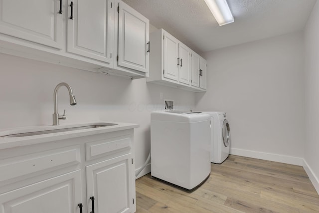 5200 Colt Ct, Westerville, OH 43081 - laundry area featuring cabinet space, separate washer and dryer, light wood-style flooring, and a textured ceiling