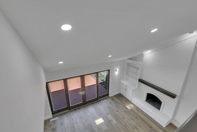 5200 Colt Ct, Westerville, OH 43081 - unfurnished living room with wood finished floors, french doors, recessed lighting, and a brick fireplace