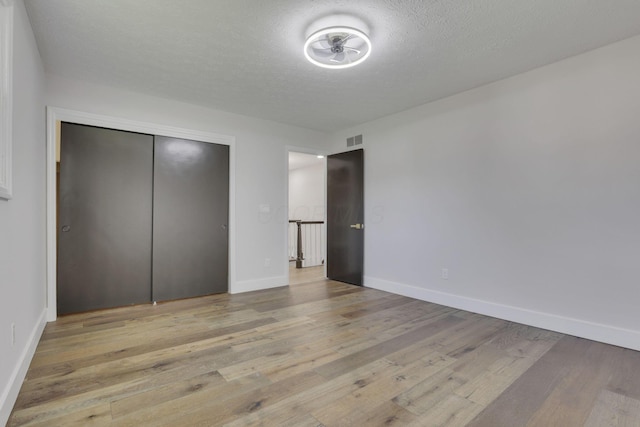 5200 Colt Ct, Westerville, OH 43081 - unfurnished bedroom with light wood-style flooring, a closet, and a textured ceiling