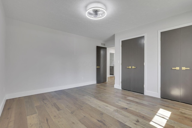 5200 Colt Ct, Westerville, OH 43081 - unfurnished bedroom with wood finished floors, multiple closets, and a textured ceiling