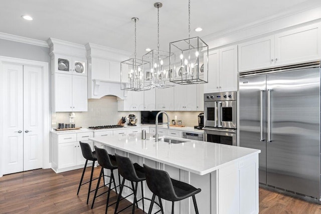 1372 Dogwood Loop, Powell, OH 43065 - kitchen with stainless steel appliances, a chandelier, ornamental molding, a breakfast bar, and tasteful backsplash