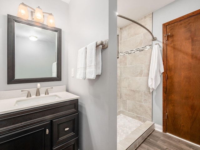 2247 Sonnington Dr, Dublin, OH 43016 - bathroom featuring a tile shower, vanity, and wood finished floors