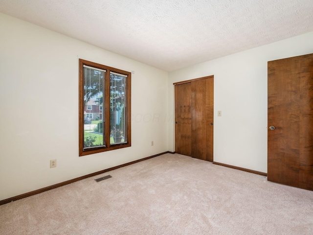 2247 Sonnington Dr, Dublin, OH 43016 - unfurnished bedroom featuring light carpet, a textured ceiling, and a closet
