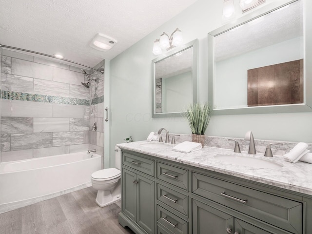 2247 Sonnington Dr, Dublin, OH 43016 - bathroom featuring wood finished floors, double vanity, a textured ceiling, and shower / bath combination