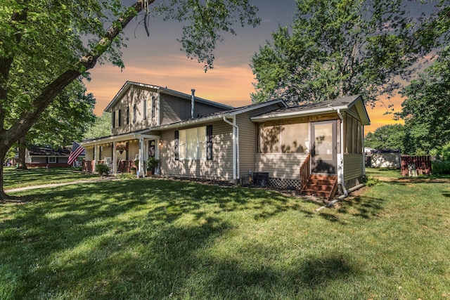 691 Heritage Blvd, Delaware, OH 43015 - back of property with a lawn, entry steps, a sunroom, and a porch