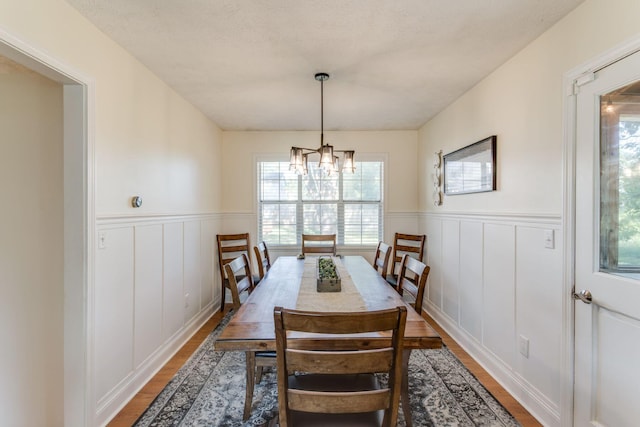 691 Heritage Blvd, Delaware, OH 43015 - dining area with a wainscoted wall, a decorative wall, a chandelier, and wood finished floors