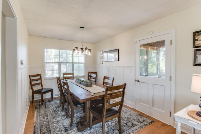 691 Heritage Blvd, Delaware, OH 43015 - dining area featuring a wainscoted wall, healthy amount of natural light, light wood-type flooring, and a chandelier