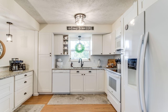 691 Heritage Blvd, Delaware, OH 43015 - kitchen featuring white appliances, light wood-style flooring, white cabinetry, backsplash, and a textured ceiling