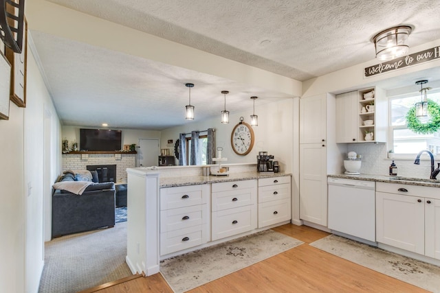 691 Heritage Blvd, Delaware, OH 43015 - kitchen with white dishwasher, a peninsula, light wood-style floors, healthy amount of natural light, and a textured ceiling