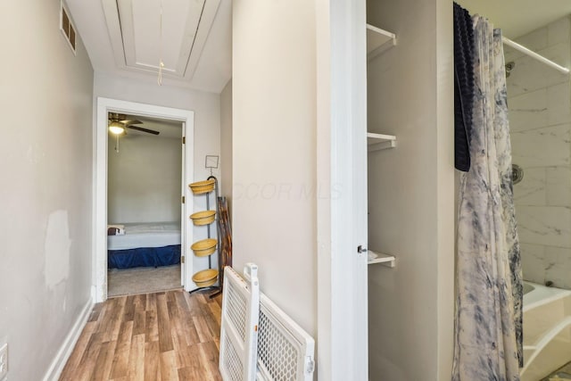 137 Wisconsin Ave, Columbus, OH 43222 - bathroom featuring wood finished floors, shower / bath combo with shower curtain, and heating unit