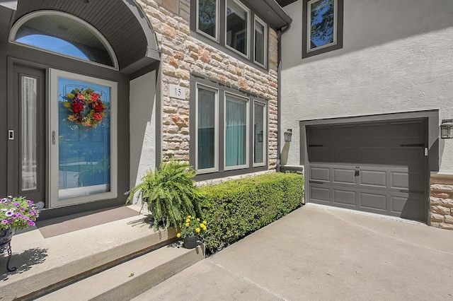 15 Doe St, Plain City, OH 43064 - property entrance with stucco siding, stone siding, an attached garage, and concrete driveway
