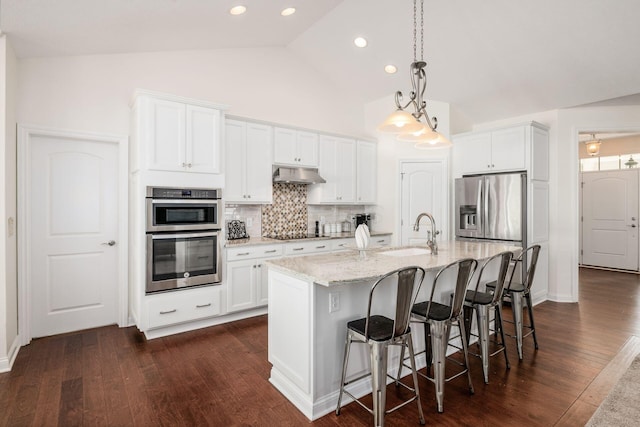 174 Grand Ridge Ct, Gahanna, OH 43230 - kitchen featuring under cabinet range hood, appliances with stainless steel finishes, white cabinets, tasteful backsplash, and an island with sink