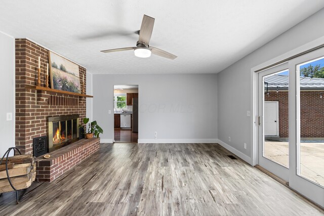 1550 Hiner Rd, Orient, OH 43146 - unfurnished living room with healthy amount of natural light, a brick fireplace, wood finished floors, and ceiling fan