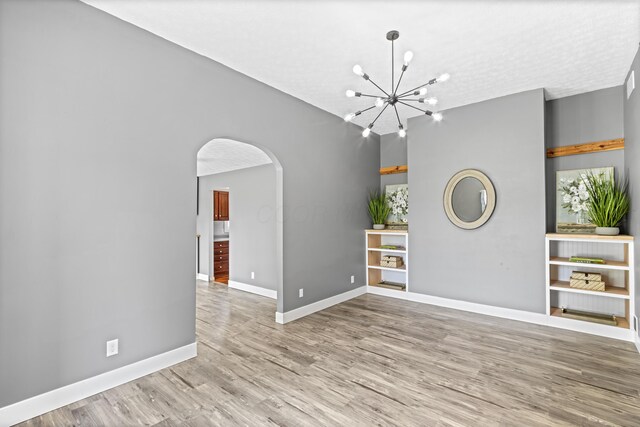 1550 Hiner Rd, Orient, OH 43146 - spare room featuring arched walkways, a chandelier, and wood finished floors