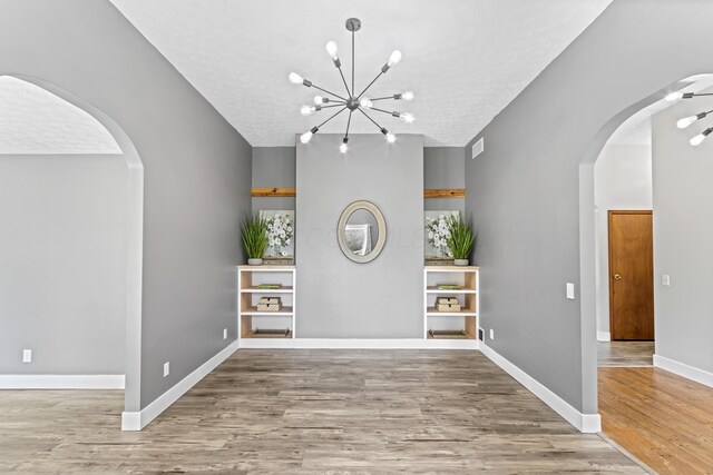 1550 Hiner Rd, Orient, OH 43146 - foyer entrance with arched walkways, wood finished floors, a chandelier, and a textured ceiling