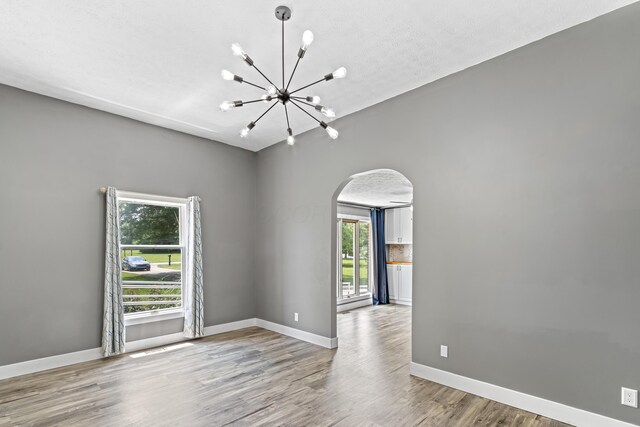 1550 Hiner Rd, Orient, OH 43146 - spare room featuring arched walkways, a chandelier, and wood finished floors
