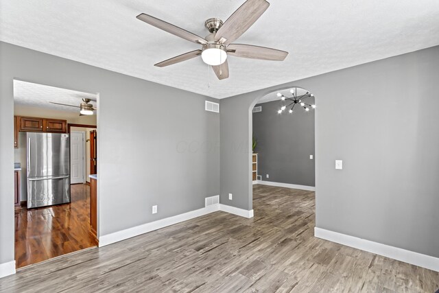 1550 Hiner Rd, Orient, OH 43146 - spare room with arched walkways, ceiling fan, wood finished floors, a chandelier, and a textured ceiling