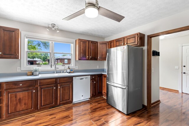 1550 Hiner Rd, Orient, OH 43146 - kitchen with dishwasher, freestanding refrigerator, light countertops, wood finished floors, and a textured ceiling