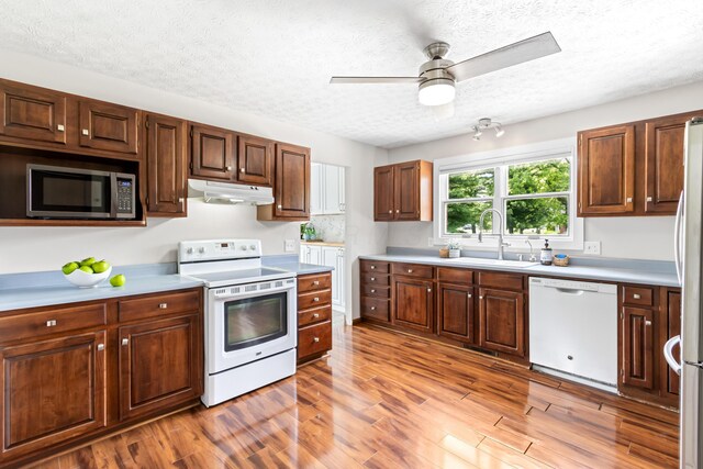 1550 Hiner Rd, Orient, OH 43146 - kitchen featuring white appliances, under cabinet range hood, a textured ceiling, light wood-type flooring, and light countertops