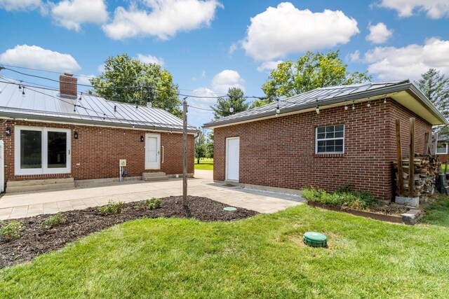 1550 Hiner Rd, Orient, OH 43146 - view of property exterior featuring entry steps, brick siding, a lawn, a standing seam roof, and a patio area