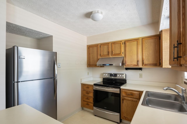 1176 Cambridge Way, Pickerington, OH 43147 - kitchen featuring stainless steel appliances, under cabinet range hood, a textured ceiling, light countertops, and brown cabinets