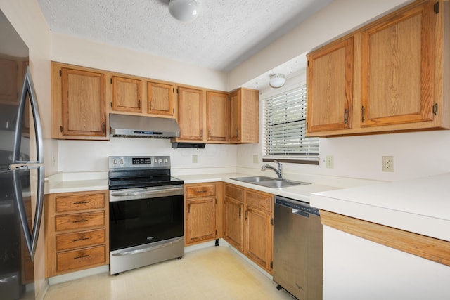 1176 Cambridge Way, Pickerington, OH 43147 - kitchen with stainless steel appliances, under cabinet range hood, a textured ceiling, light countertops, and brown cabinetry