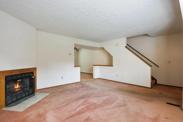 1176 Cambridge Way, Pickerington, OH 43147 - unfurnished living room featuring stairs, carpet, a tiled fireplace, and a textured ceiling