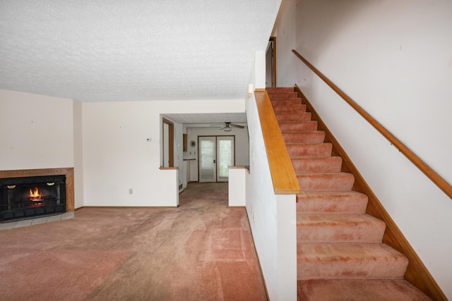 1176 Cambridge Way, Pickerington, OH 43147 - stairway with carpet floors, a ceiling fan, a warm lit fireplace, and a textured ceiling