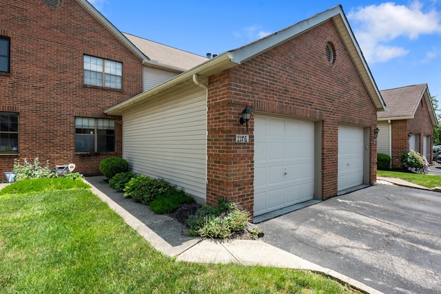 1176 Cambridge Way, Pickerington, OH 43147 - view of home's exterior featuring driveway, brick siding, an attached garage, and a yard