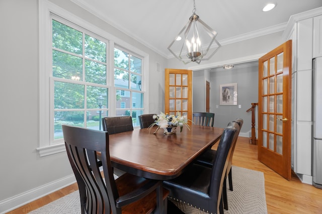 1359 White Oak Ln, New Albany, OH 43054 - dining area featuring crown molding, french doors, a chandelier, plenty of natural light, and light wood-style floors