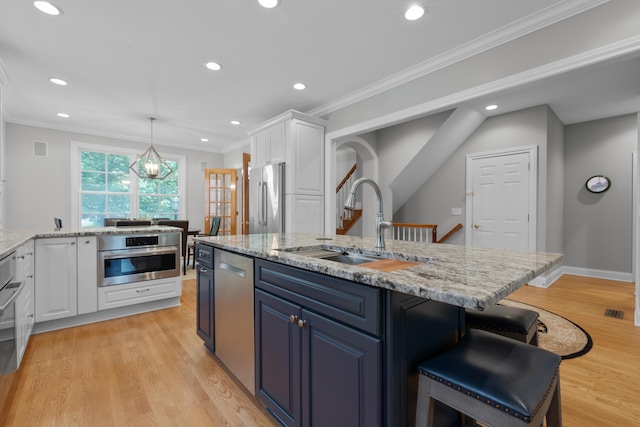 1359 White Oak Ln, New Albany, OH 43054 - kitchen featuring stainless steel appliances, white cabinetry, recessed lighting, a center island with sink, and light wood-type flooring