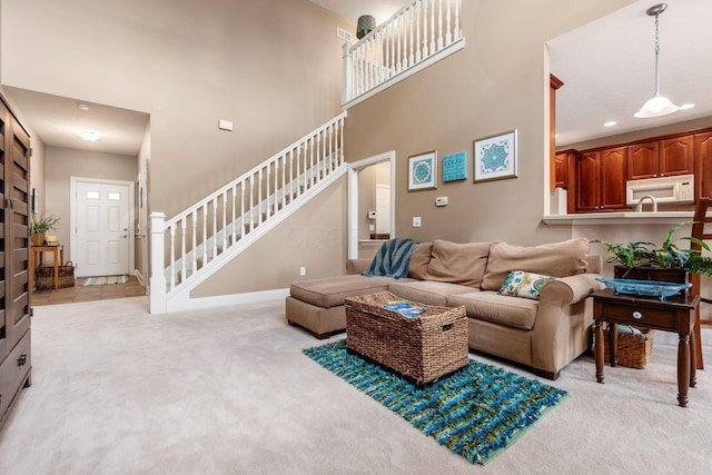 993 Starlight Ln, Westerville, OH 43082 - living room with stairway, light carpet, and a high ceiling