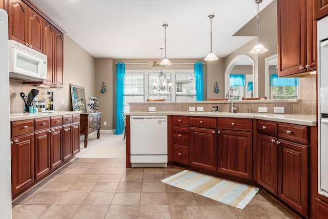 993 Starlight Ln, Westerville, OH 43082 - kitchen featuring white appliances, light countertops, decorative backsplash, a peninsula, and decorative light fixtures