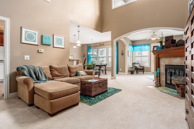 993 Starlight Ln, Westerville, OH 43082 - living area with carpet flooring, a tiled fireplace, arched walkways, a ceiling fan, and a high ceiling