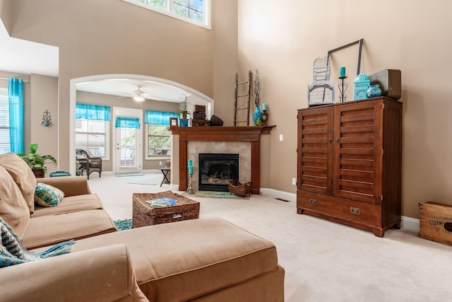 993 Starlight Ln, Westerville, OH 43082 - carpeted living room featuring healthy amount of natural light, a high ceiling, arched walkways, and a tiled fireplace