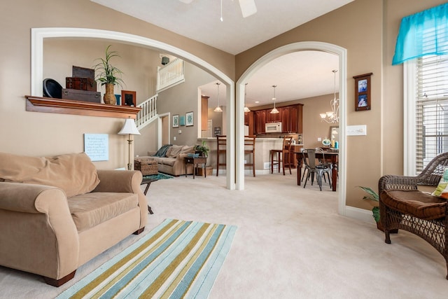 993 Starlight Ln, Westerville, OH 43082 - living room featuring light colored carpet, arched walkways, a ceiling fan, and a chandelier