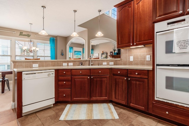 993 Starlight Ln, Westerville, OH 43082 - kitchen featuring white appliances, light countertops, a chandelier, decorative backsplash, and a peninsula