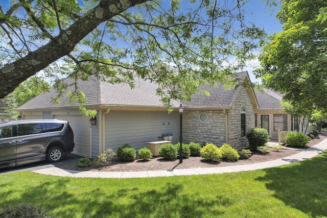 786 Stone Ridge Way, Newark, OH 43055 - view of home's exterior featuring an attached garage, a shingled roof, stone siding, and a yard
