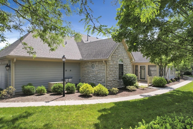 786 Stone Ridge Way, Newark, OH 43055 - view of front facade with stone siding, roof with shingles, a front yard, and a garage