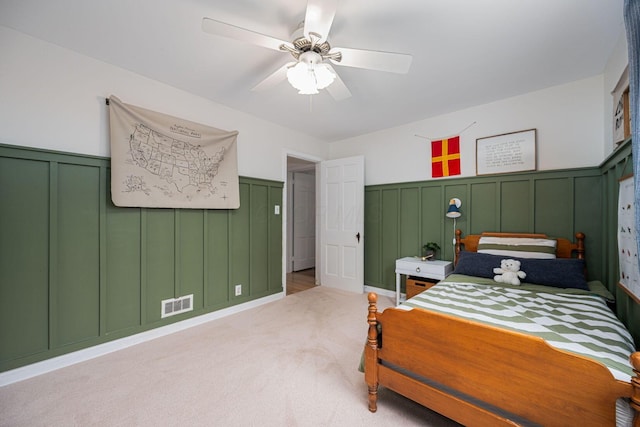 922 S Remington Rd, Columbus, OH 43209 - bedroom featuring a decorative wall, wainscoting, light colored carpet, and a ceiling fan