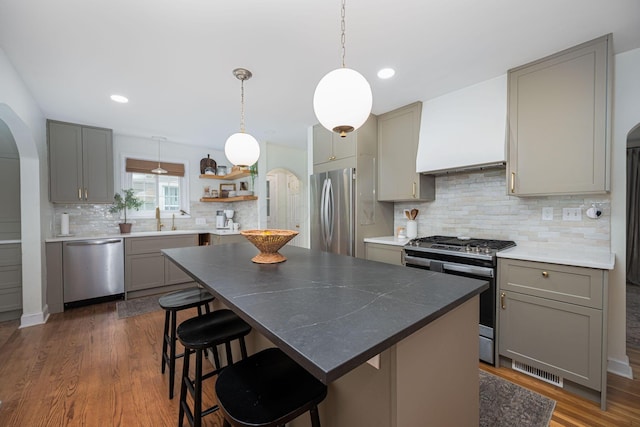 922 S Remington Rd, Columbus, OH 43209 - kitchen with appliances with stainless steel finishes, gray cabinetry, arched walkways, custom exhaust hood, and recessed lighting