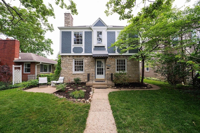 922 S Remington Rd, Columbus, OH 43209 - english style home featuring stone siding, a chimney, a front yard, and a patio area