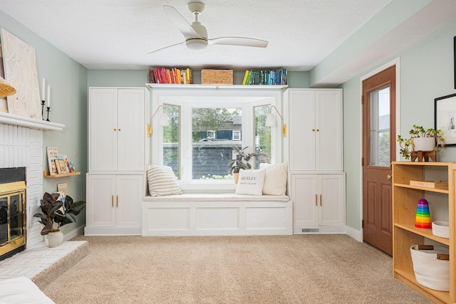 922 S Remington Rd, Columbus, OH 43209 - living area featuring light carpet, a brick fireplace, ceiling fan, and a textured ceiling