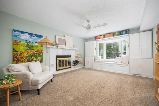 922 S Remington Rd, Columbus, OH 43209 - carpeted living area featuring a textured ceiling, ceiling fan, and a brick fireplace