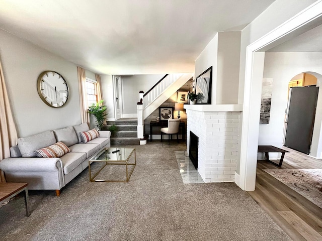 554 Laurel St, Chillicothe, OH 45601 - living area with stairs, wood finished floors, a brick fireplace, and arched walkways