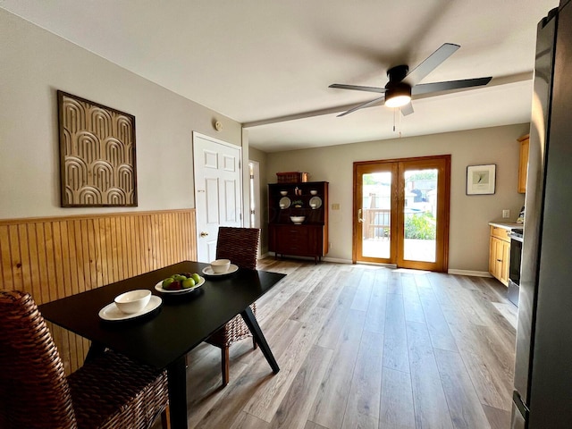 554 Laurel St, Chillicothe, OH 45601 - dining area featuring ceiling fan, light wood finished floors, and a wainscoted wall