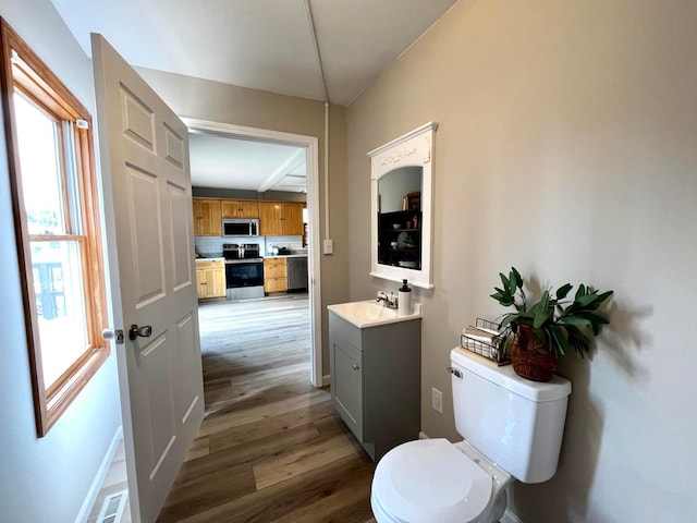 554 Laurel St, Chillicothe, OH 45601 - bathroom with vanity, wood finished floors, and decorative backsplash